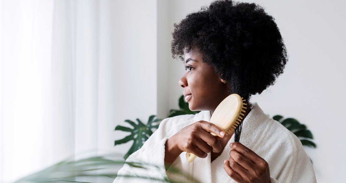 Mulher penteia os fios após usar sérum capilar ou óleo capilar